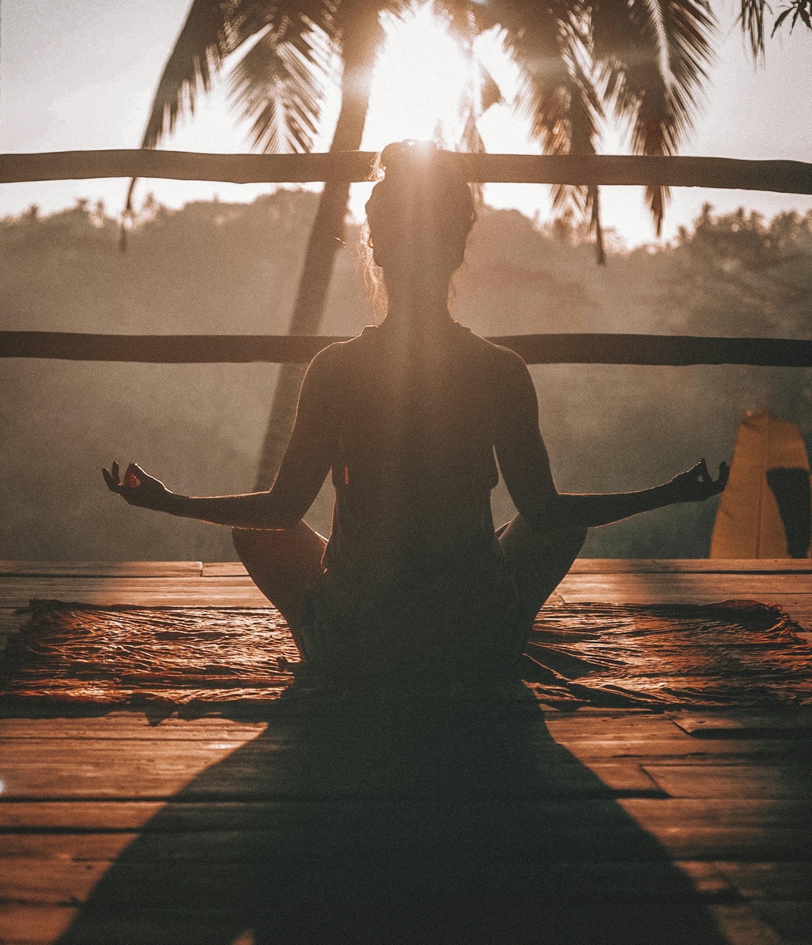 Silhouette of a person meditating toward the sun