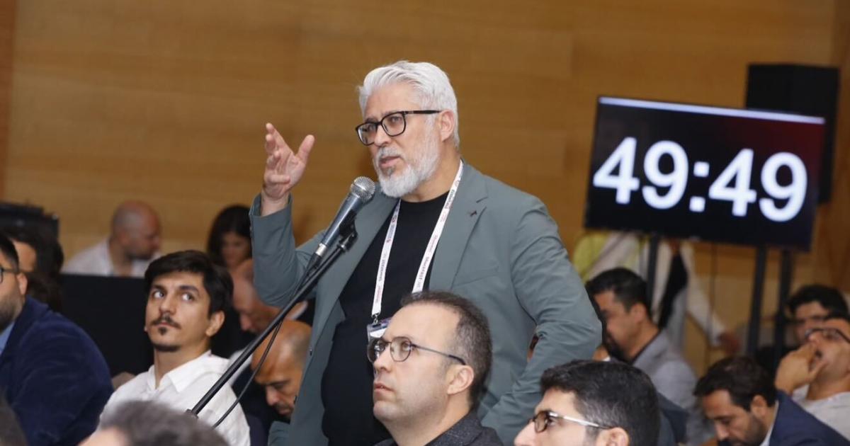 Prof. Dr. Hakan Uçar speaking with a microphone in the CTO Essentials 2025 hall